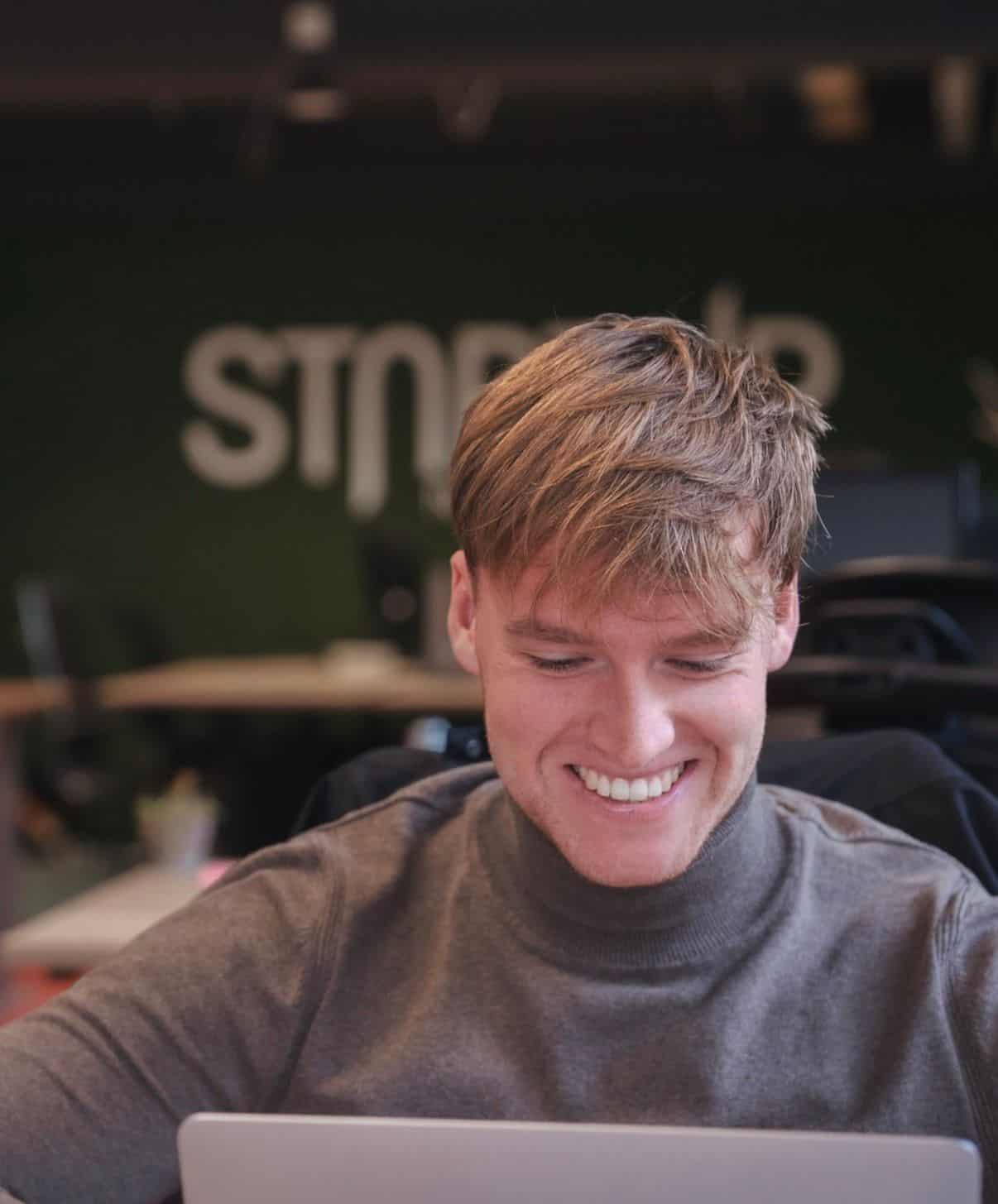 Oud-StartUpper achter een laptop voor de ondernemersblog van StartUp Nijmegen.